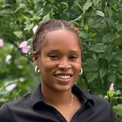 Licensed Massage Therapist Audreona Smiling In Front Of Greenery